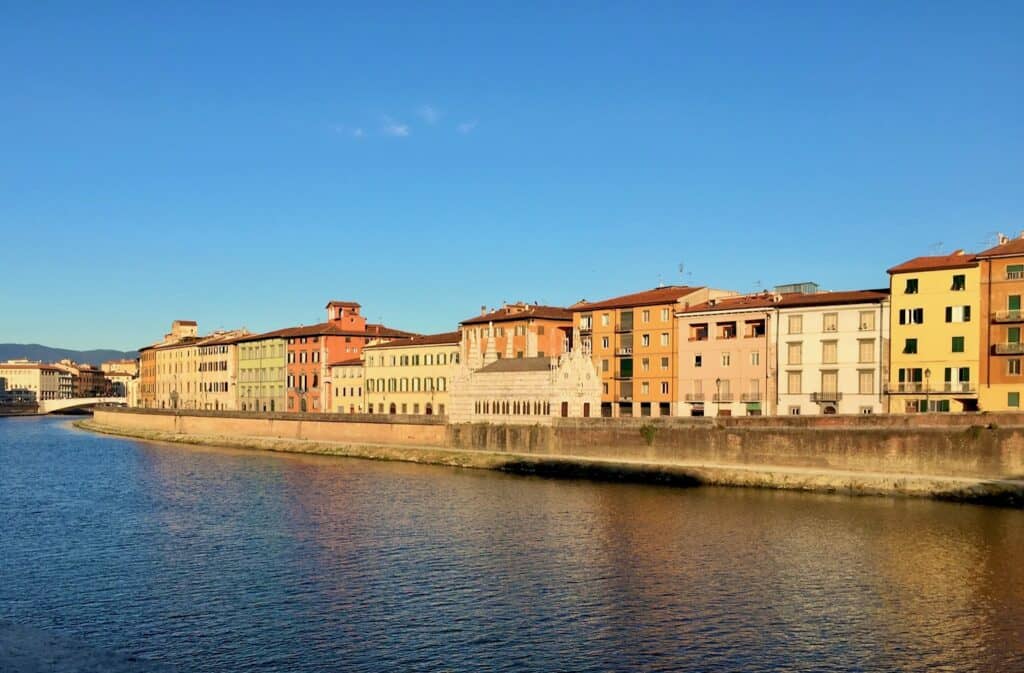 Pastel colored Italian homes line the Arno river in Pisa.