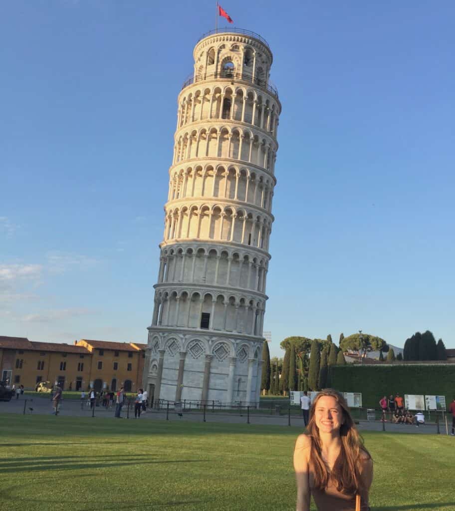 Woman standing in front of the Leaning Tower of Pisa, one of the best places to visit in Italy.