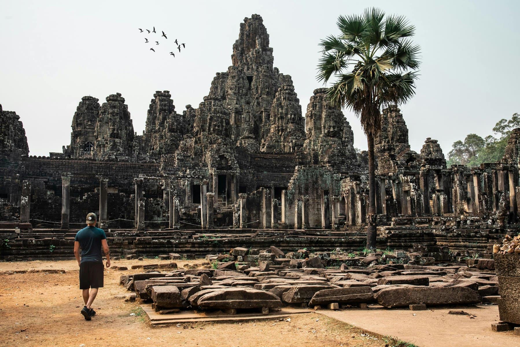 If you travel from Vietnam to Cambodia, you will be able to explore the ancient temples of Angkor Wat, featured in this picture on a sunny day.